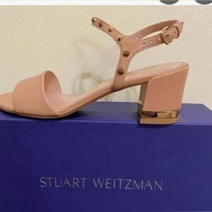 Stuart Weitzman, nude Napa leather sandals with gold studs on front strap.